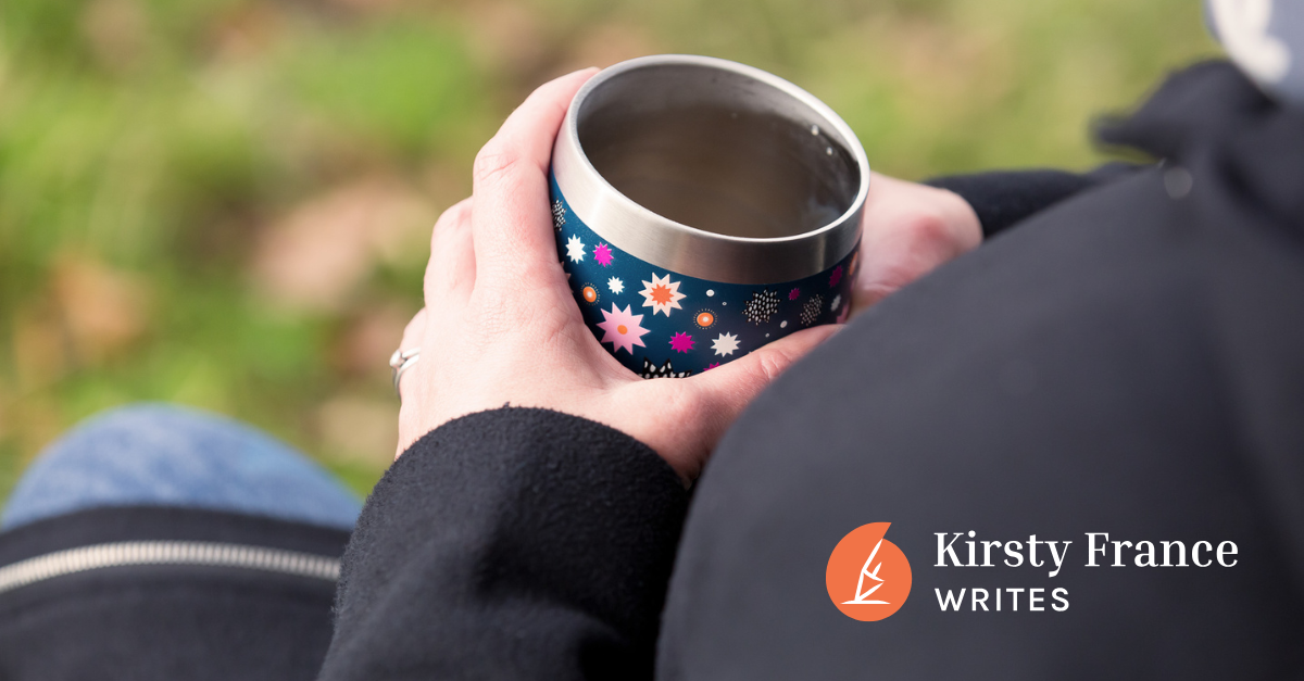 Image shows a woman's hands holding a cup, finding time to take a break.